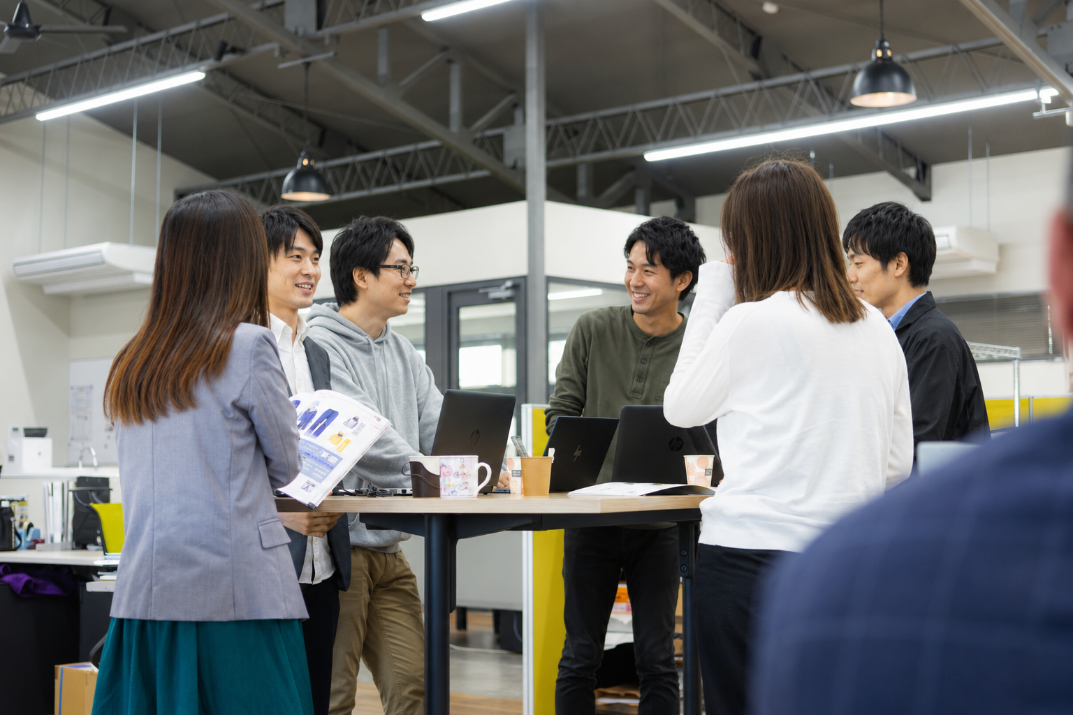オフィスで笑顔で話し合うチーム
